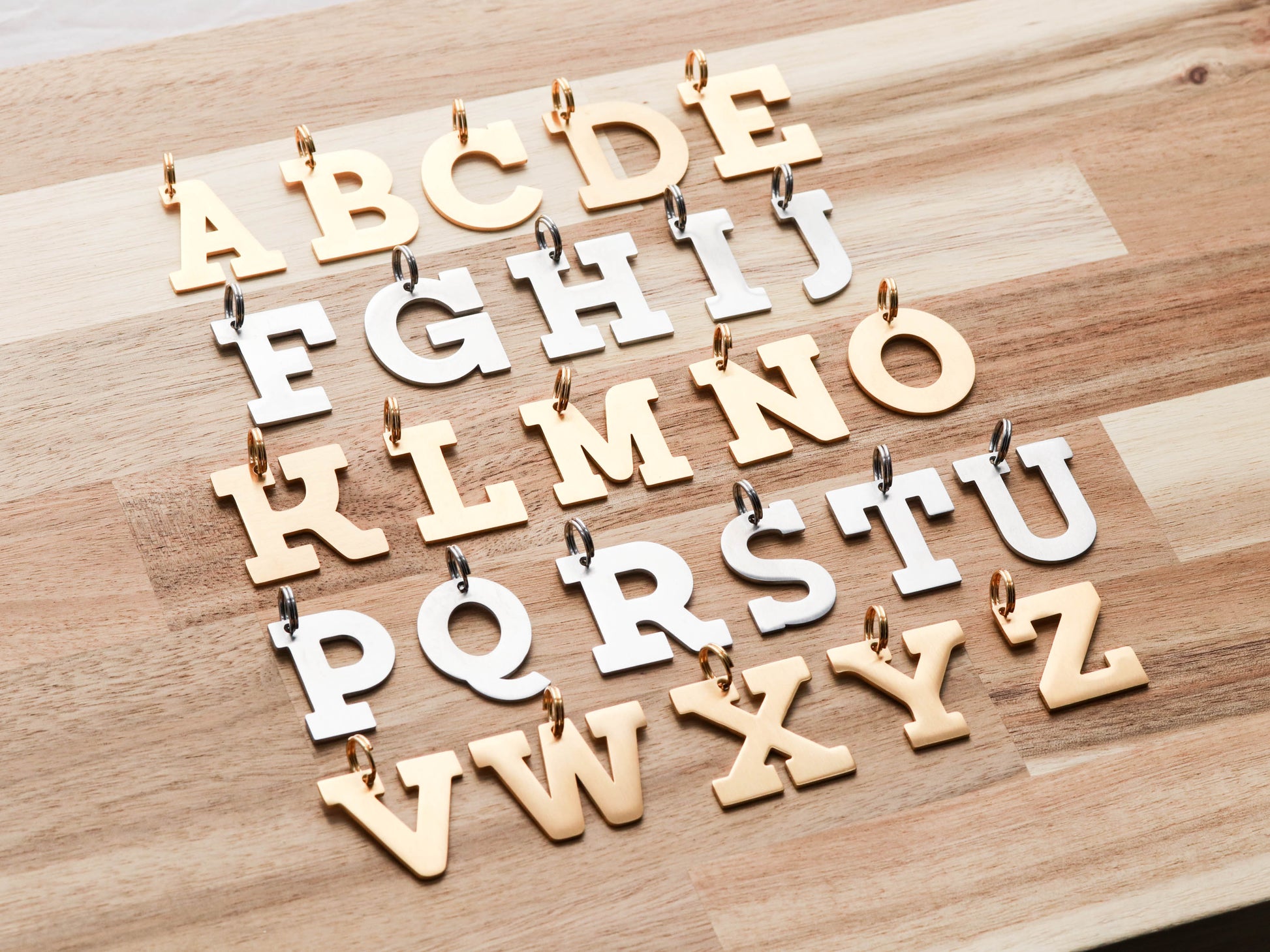 Block Letter collar charms in gold and silver.