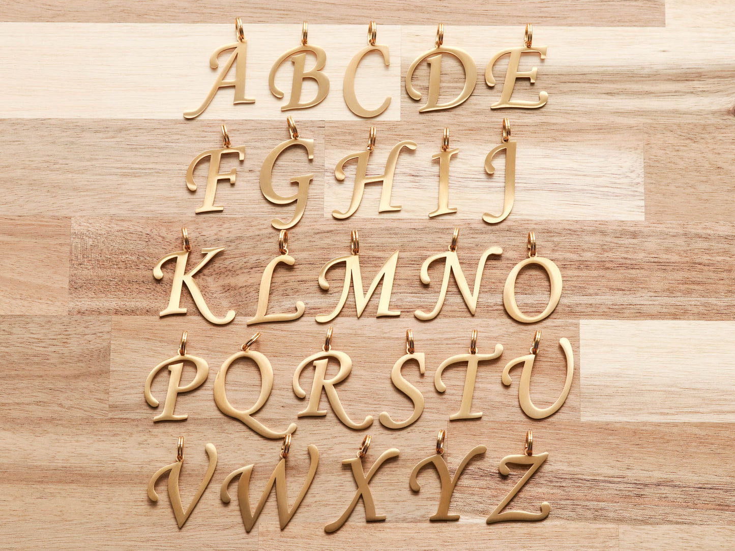 Cursive Letter Collar Charms in gold.