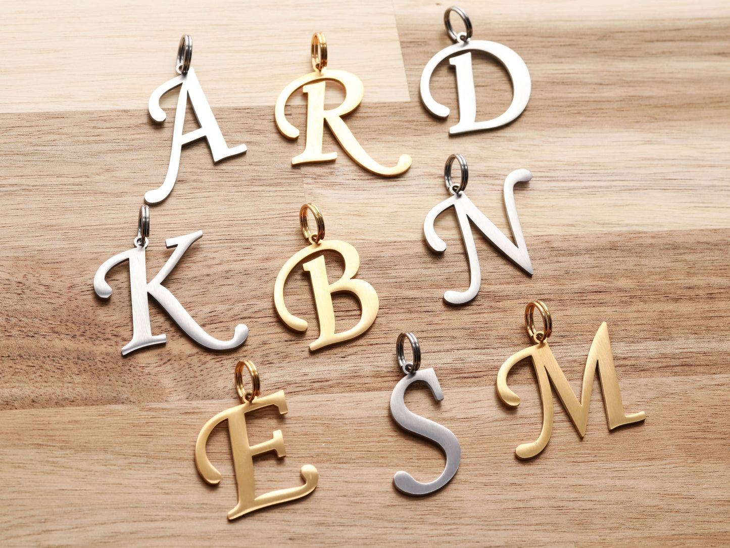Cursive Letter Collar Charms in gold and silver.